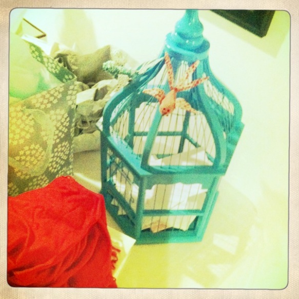 A birdcage used as a card holder on the gift table
